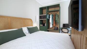 Une chambre d’hôtel moderne équipée d’un grand lit, d’une armoire, d’un bureau et d’une télévision.