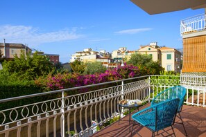 A balcony with a view of a river, surrounded by buildings and lush greenery. - Estate4home - Suites 21 (Sorrento)