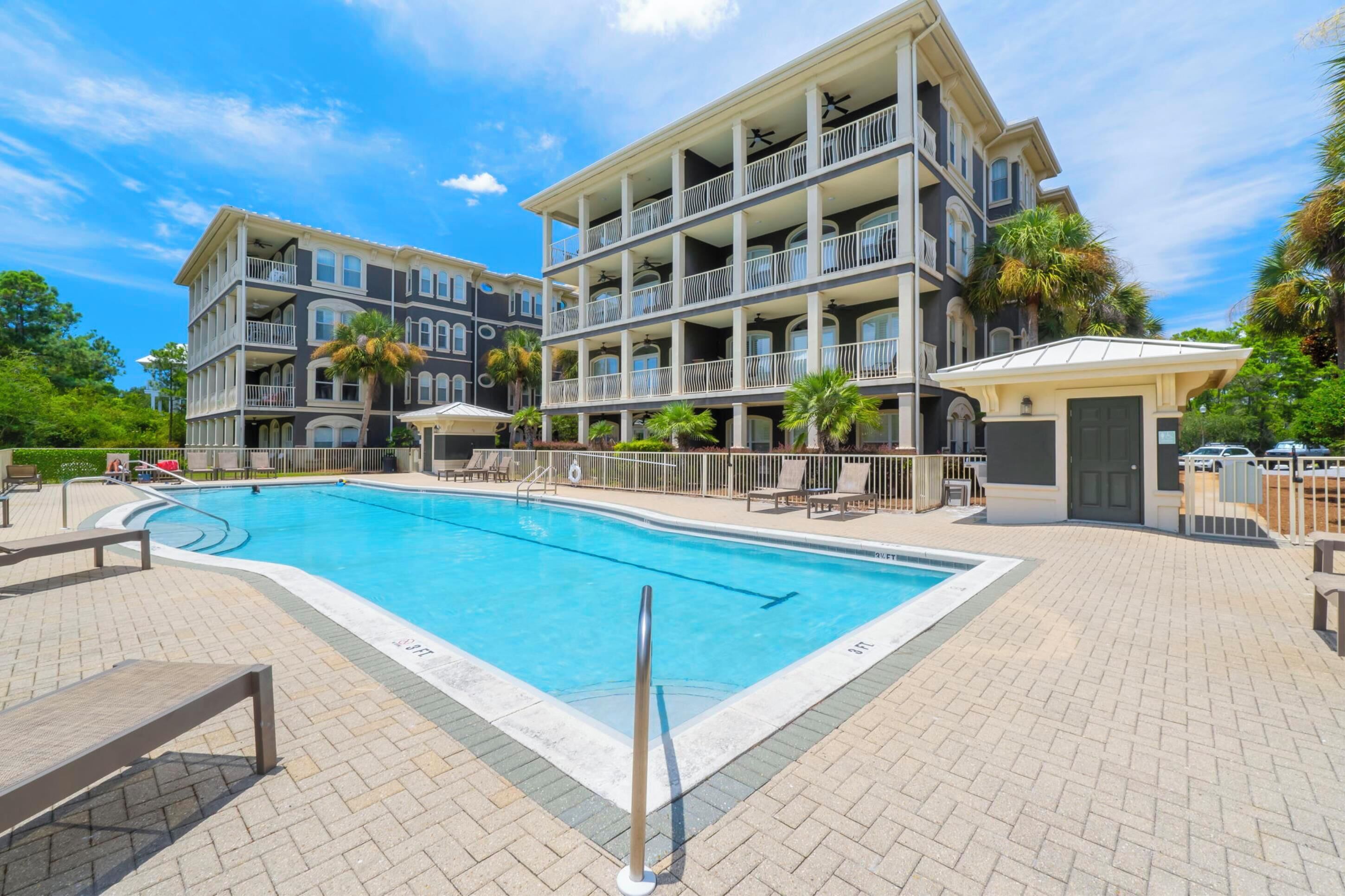 Un hôtel à plusieurs étages doté d’une piscine, d’un espace extérieur aménagé et d’une zone couverte.
