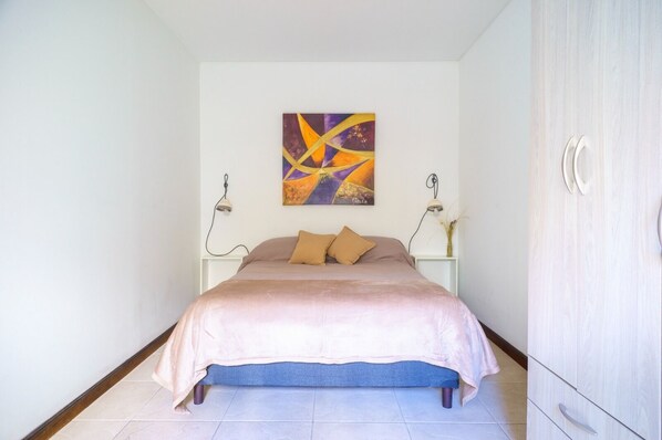 A bedroom with a bed, two bedside lamps, a wall art piece, and a wardrobe. - Nuevo y Acogedor Dto, en el Corazón de Mendoza, Tranquilo, con Cochera (Mendoza)