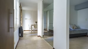 Un interno moderno con angolo pranzo, divano e parete divisoria in vetro.