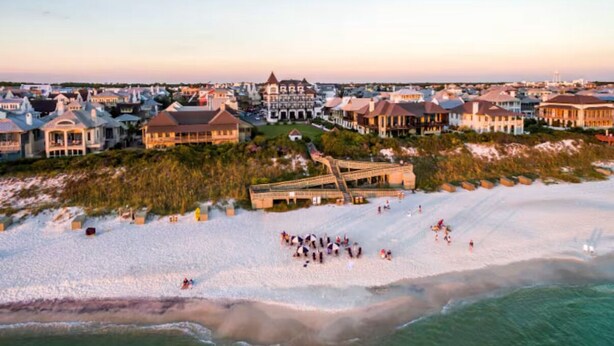 A coastal area with beachfront properties, a boardwalk, and a sandy beach.