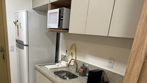 Une cuisine moderne équipée d’un réfrigérateur, d’un four à micro-ondes, d’un évier et d’une cuisinière.