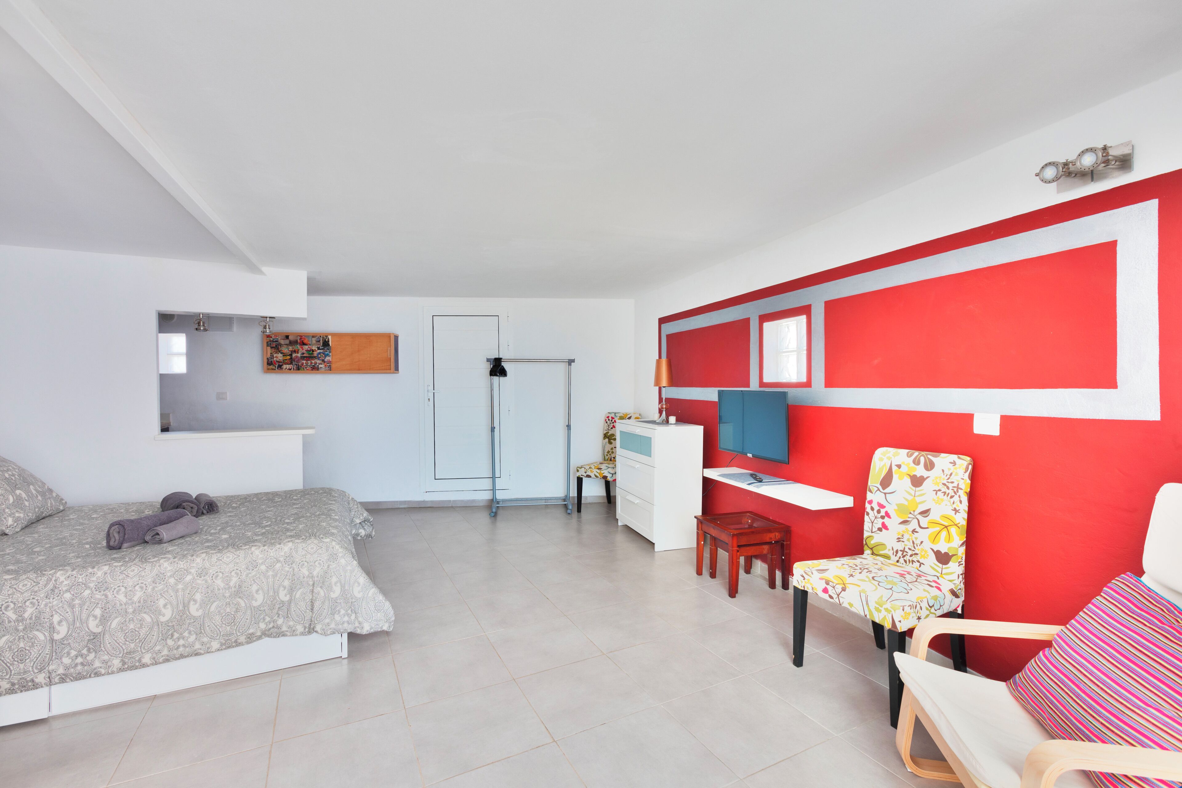 A modern bedroom with a bed, a desk, and a chair.