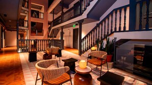 A spacious lobby with a checkered floor, multiple seating areas, and a staircase connecting different levels. - Motto by Hilton Cusco (Cusco)