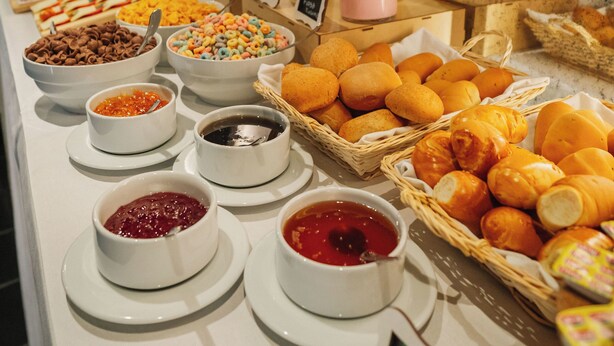 A buffet with various food items including breads, pastries, and condiments. - Motto by Hilton Cusco (Cusco)