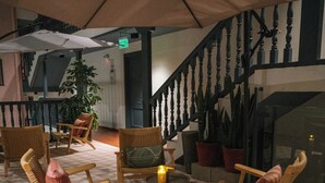 A cozy outdoor seating area with wicker furniture and a patterned floor, featuring a staircase and potted plants. - Motto by Hilton Cusco (Cusco)