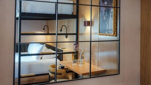 A room with bunk beds, a wooden table with glasses and a bottle, and a framed picture on the wall. - Motto by Hilton Cusco (Cusco)