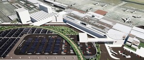 An airport terminal with a large parking area, multiple gates, and a modern building structure.