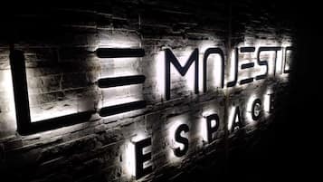 Un mur orné de lettres illuminées qui épellent les mots « LE MOJESTE ESPAG ».