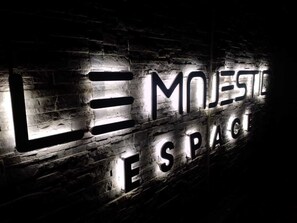 Una pared con luces que deletrean "LE MOJESTE ESPAG".