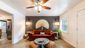 Un salon moderne avec un canapé marron, une table basse ronde et un ventilateur de plafond.