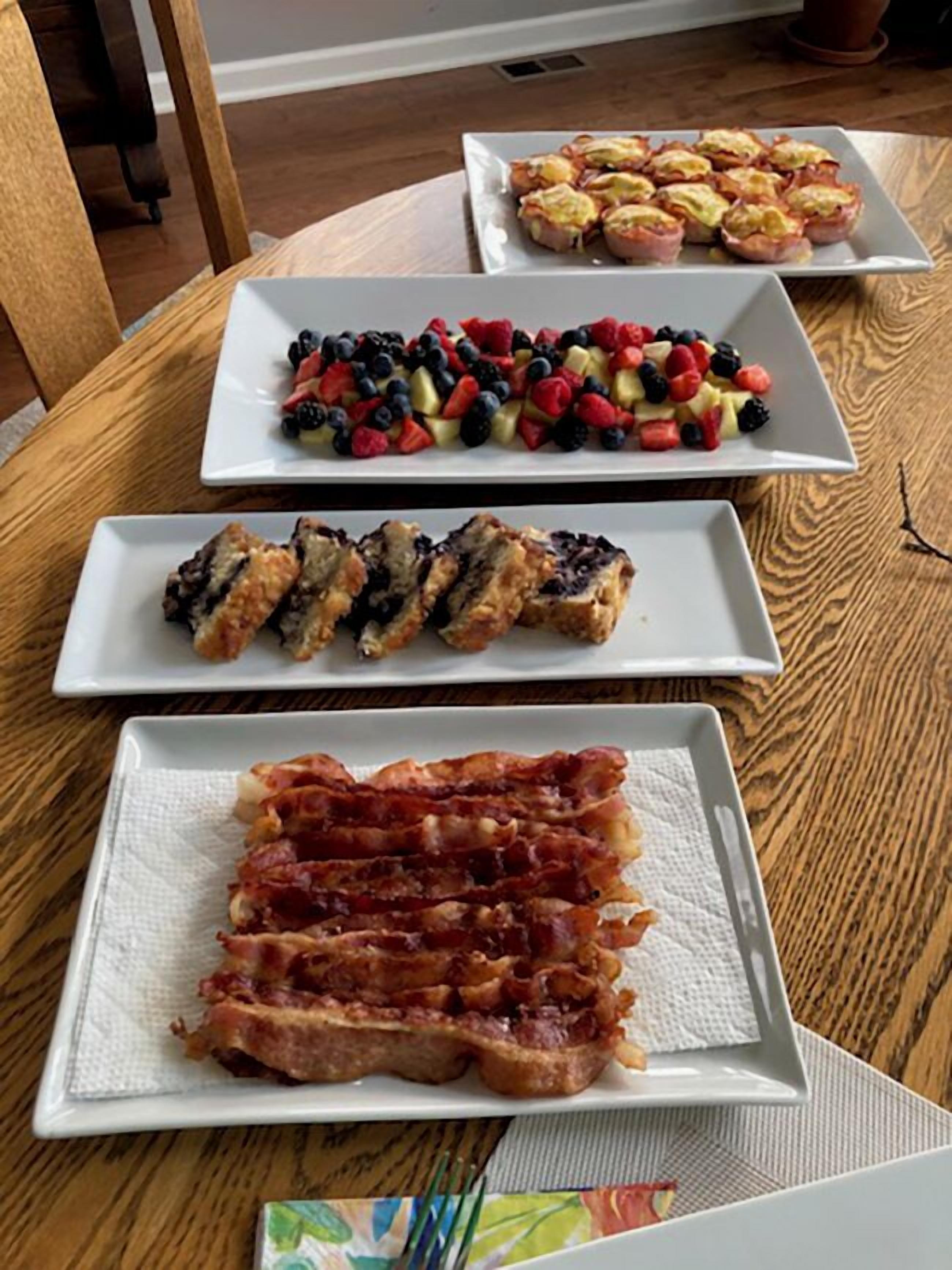 A table with three square plates of food.