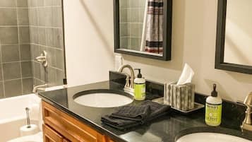 A bathroom with two sinks, a toilet, and a shower.