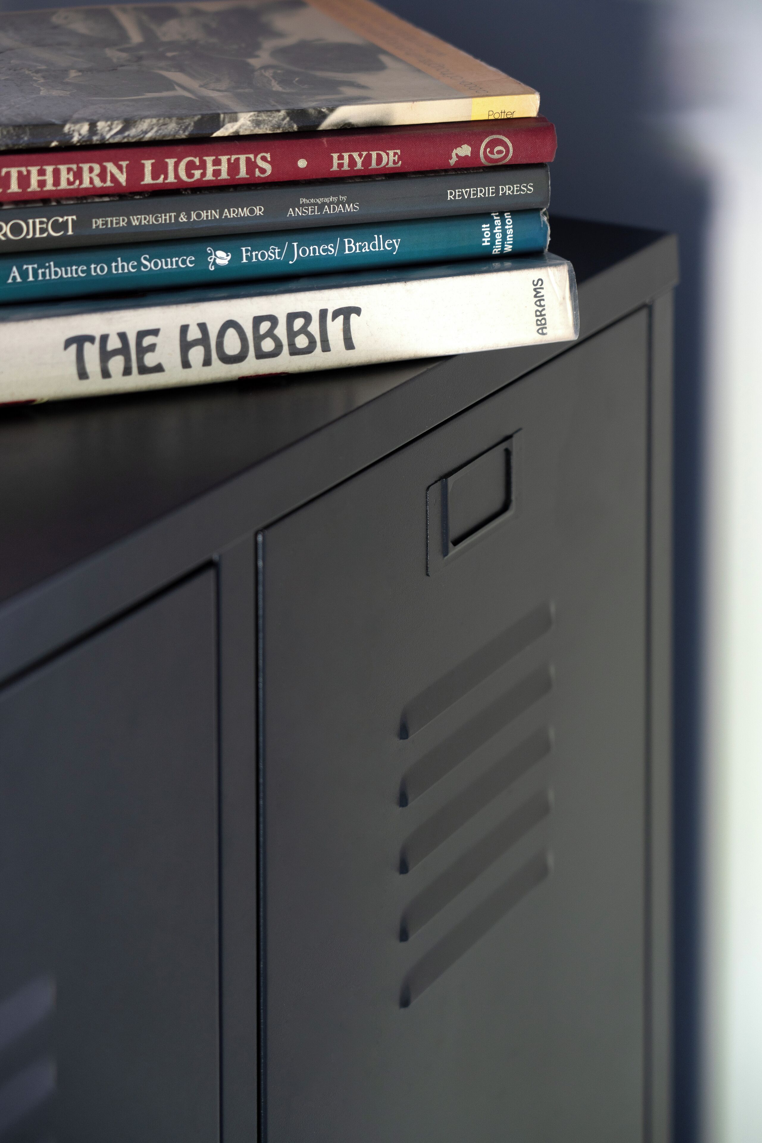 A stack of books on a metal cabinet.