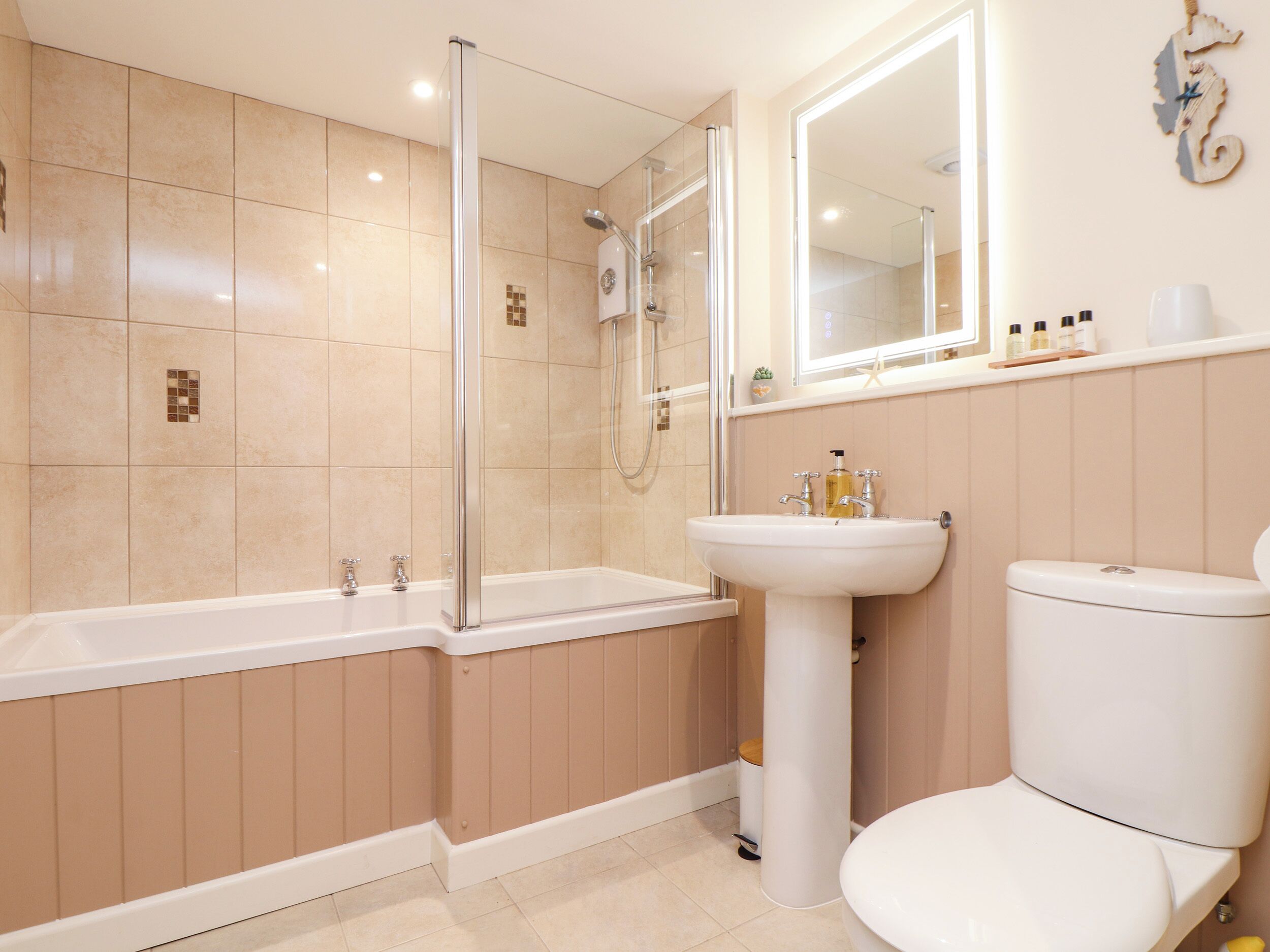 Ein modernes Badezimmer mit einer Duschkabine, einem weißen Waschbecken und einer Toilette.