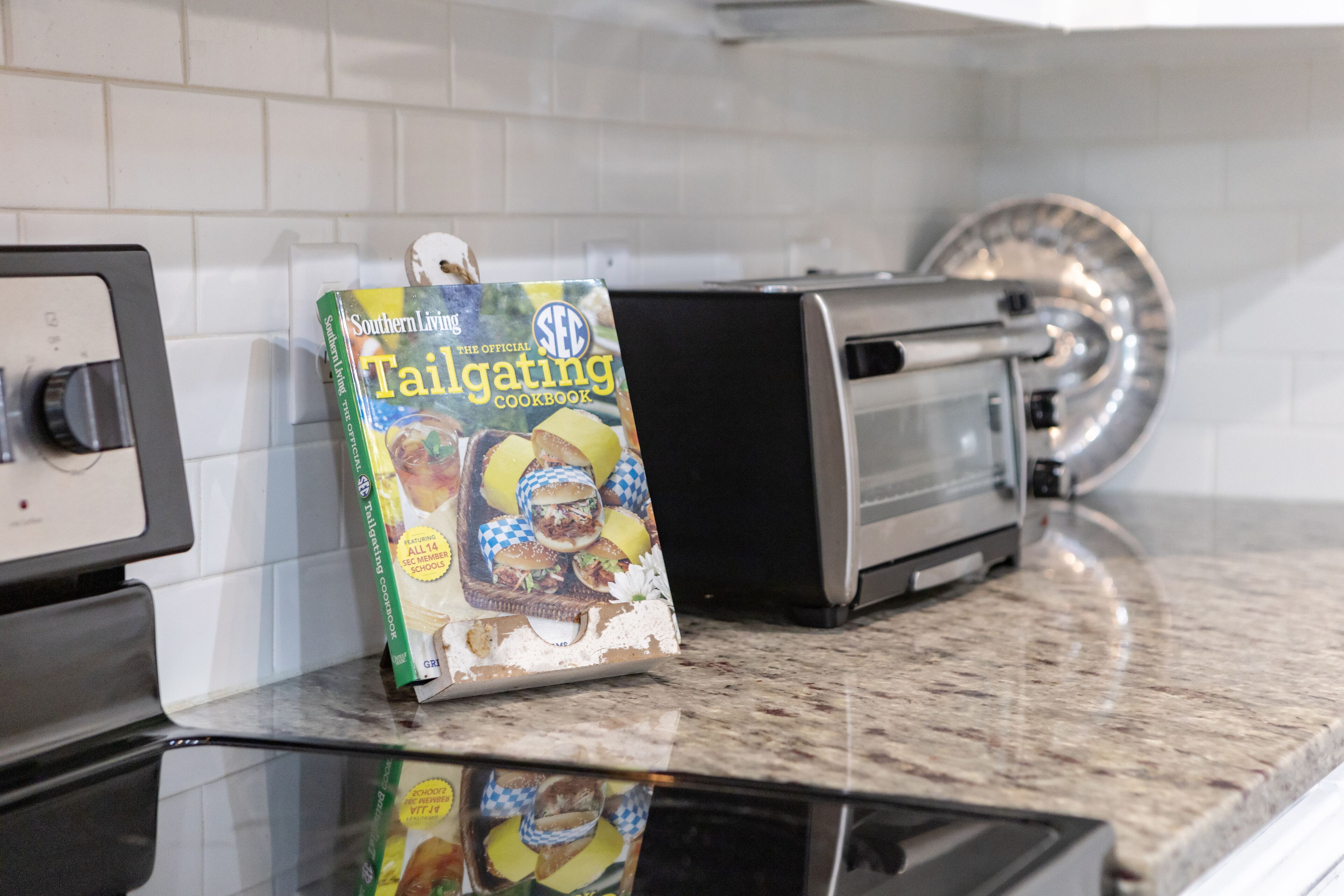 A kitchen with a countertop, a toaster, and a cookbook titled 'Southern Living Tailgating Cookbook'.