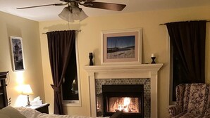 A bedroom with a bed, a chair, a fireplace, and a ceiling fan. - Intimité et Confort, Plusieurs Foyers, à Proximité D'activités et Sherbrooke (Sherbrooke)