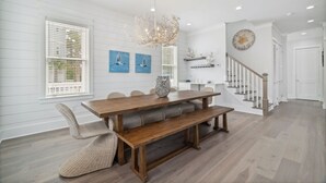 A dining area with a wooden table, bench seating, and a chandelier. - 30A Beach House - 30A Wonderland by PHG (Panama City Beach)