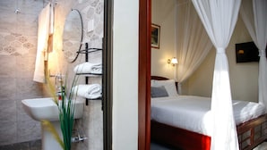 A bathroom with a sink, mirror, and towel rack. - Fred and Winnie BnB (Kampala)
