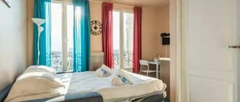 Escritorio, tabla de planchar con plancha, wifi y ropa de cama