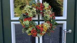 A green door with a white-framed window and a wreath hanging on it. - Cozy vacation apartment with complete equipment for up to 5 people (Bötersen)