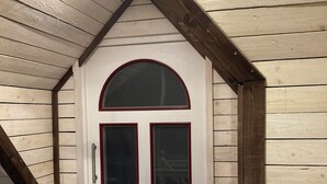 A wooden exterior with a white door and a small balcony. - Cozy vacation apartment with complete equipment for up to 5 people (Bötersen)