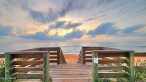 Un muelle de madera que conduce a una playa bajo un cielo nublado.