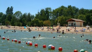 A beach with swimmers and a small building in the background. - Charming Cottage with exclusive use of the Jacuzzi upon request
 (Val-de-Bonnieure)