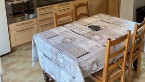 Eine kleine Küche mit Holzausstattung, einer Mikrowelle, einem Backofen und einer Waschmaschine.