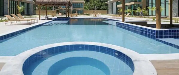 A swimming pool with lounge chairs and a thatched roof structure. - Paradise is waiting for you (Sap Miguel dos Milagros)