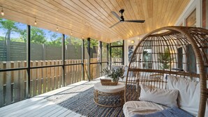 A covered outdoor seating area with a ceiling fan, wicker furniture, and a view of the backyard. - 30A Beach House - Dream Chaser by PHG (Santa Rosa Beach)