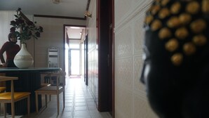 Una habitación con una mesa de comedor, sillas, un florero con flores y un espejo.