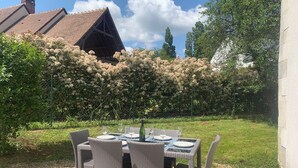 An outdoor dining area with wicker furniture and a table set for four.