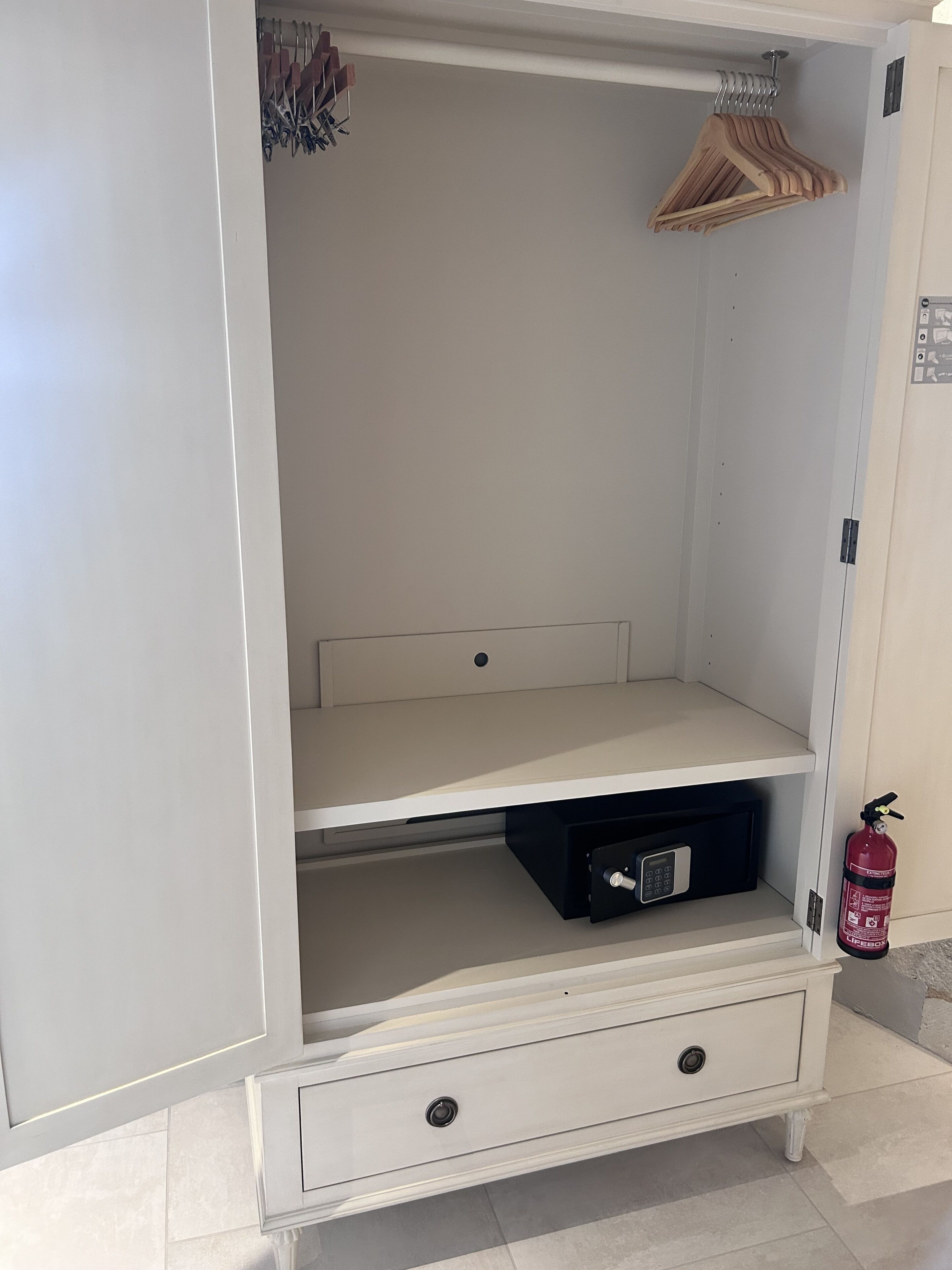 Ein weißer Kleiderschrank mit Kleiderstange, einer Schublade und einem Fach.