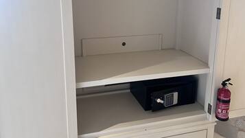 Ein weißer Kleiderschrank mit Kleiderstange, einer Schublade und einem Fach.