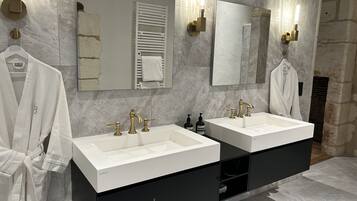 Un bagno moderno con due lavabi, uno specchio grande e un porta asciugamani.