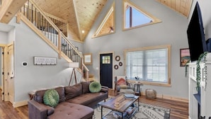 A spacious living room with a brown leather sofa, a coffee table, and a staircase with wooden railings. - ATV Trailer Parking/NEW/5 min to Natural Bridge (Campton)