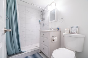 Ein Badezimmer mit Dusche, Toilette und Waschbecken.