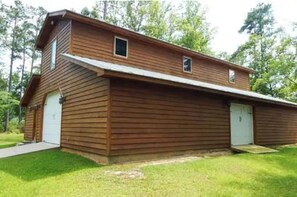 Un bâtiment en bois doté de deux portes de garage et d’un petit espace porche.