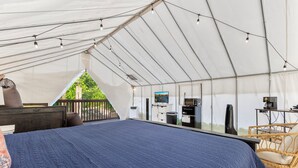 A tented accommodation with a bed, a television, and a small desk area. - Furnished Glamping Tent/King Bed/Access to the Red River - Dancing Deer - #6 (Stanton)