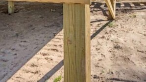 Una struttura in legno con un cartello di avvertimento che segnala un’area a rischio di allagamento.