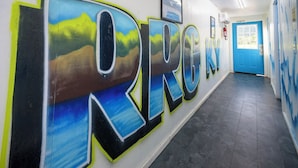 A hallway with a mural spelling "KIRG" and a blue door at the end.