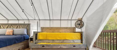 A bedroom with a wooden bed, a bedside table, and a fan.