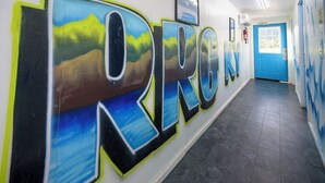 A hallway with a mural spelling "KIRG" and a blue door at the end.