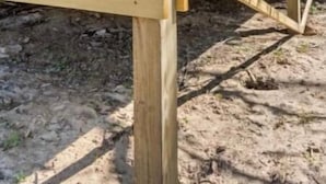 A wooden structure with a warning sign indicating a flood area.