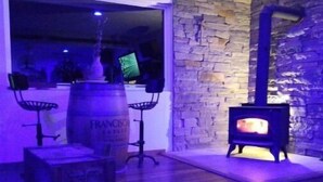A room with a stone wall, a wooden barrel, a small stove, and a chair. - Creeks Edge offers  full access to charming 8 acres along the river.
 (Canandaigua)