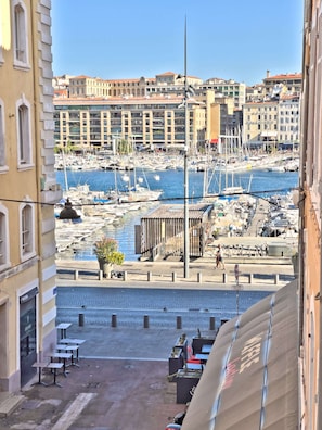 Stroll along the marina, surrounded by boats and waterfront buildings with balconies and flat facades.