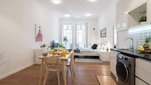 Een modern appartement met een eethoek, keuken en een bed.