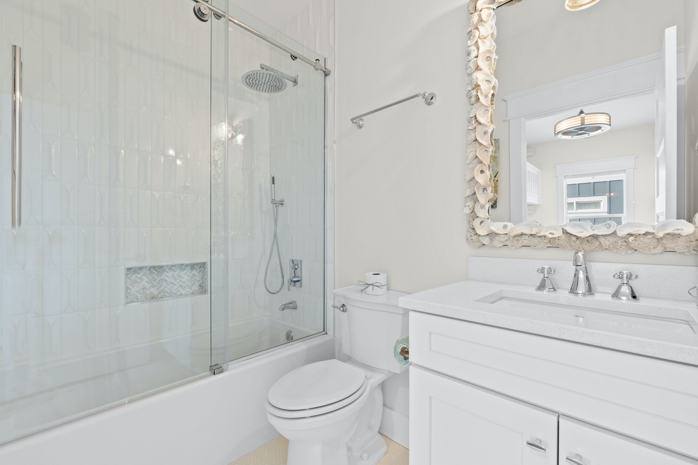 A modern bathroom with a glass-enclosed shower, a white toilet, and a vanity with a mirror.